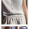 Close-up of a white knitted cotton shirt top displayed on a model.
