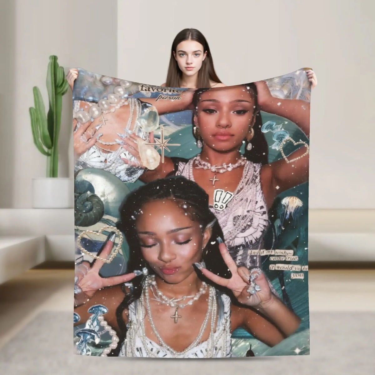 A woman is holding a large print featuring a woman and text, against a blurred indoor background.