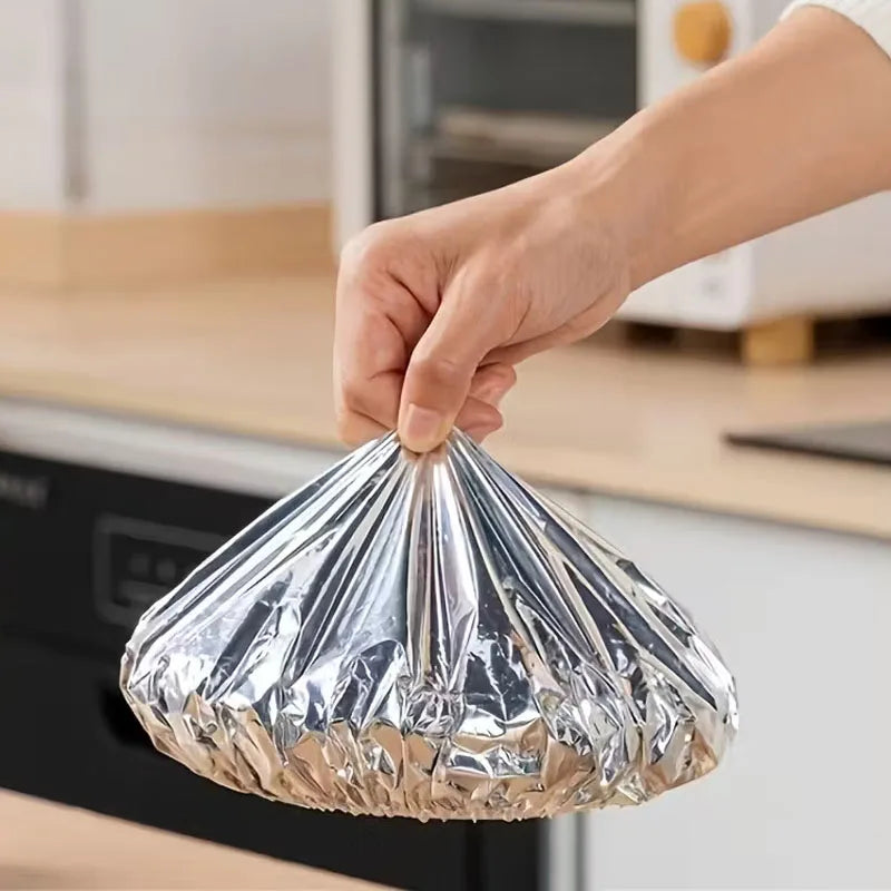 Eine Hand hält eine klare, wiederverwendbare Aluminium-Lebensmitteltopftasche über einen Küchengegenstand.