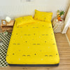 A bright yellow fitted bed sheet with a black star and squiggle pattern is displayed on a bed.