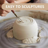 A hand is sculpting a pale beige air-dry clay piece on a gray surface.