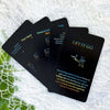 A stack of black oracle cards titled Future Love, Never, and Let It Go are displayed on a white surface.