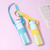 A light blue mesh water bottle carrier with yellow straps is displayed on a pink background.