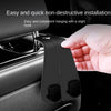 A hand is installing a non-destructive car headrest hook onto a vehicle seat.