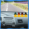 Interior view of a car dashboard showing controls and a row of yellow rubber duck ornaments