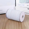 A roll of white polyester elastic bands for sewing and crafts placed on a wooden surface.