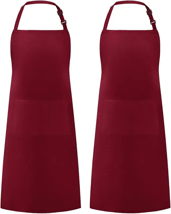 A set of two solid maroon kitchen aprons with pockets.