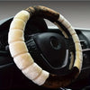 A close-up of a steering wheel covered in brown leather and white plush material.