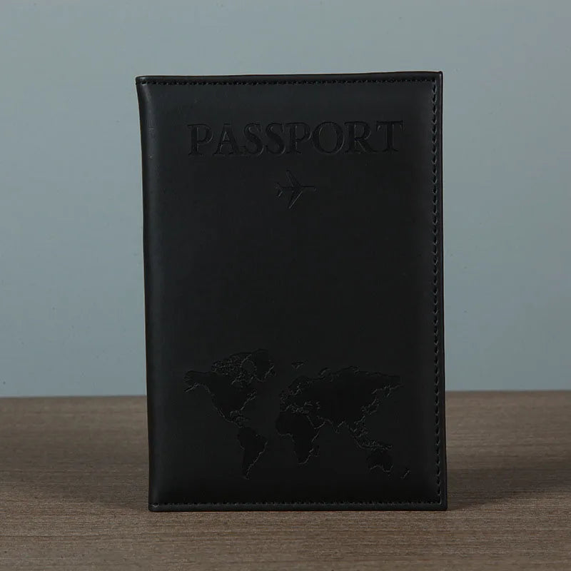 Black leather passport holder with embossed world map and a small airplane design.