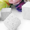 White natural mineral molar stones for small pets resting on a white surface with colorful flowers in the background