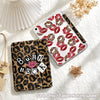 A leopard print tri-fold iPad case with a red lip print design and a wooden pencil holder.