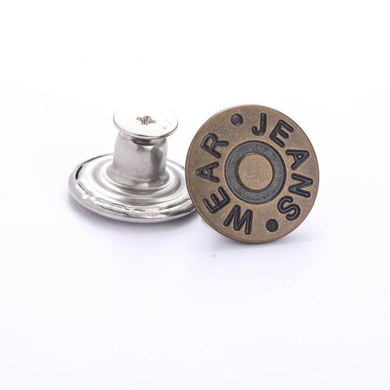 A round, bronze button with the engraved text 'JEANS' and a silver button repair kit component.