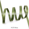 A roll of olive green moss colored satin ribbon coiled and unwound.