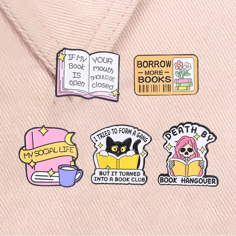 A set of four enamel pins featuring literary quotes and themes like book hoarding social life and book hangover