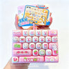 A pink set of 26 cartoon keycap fidget items and a yellow instruction card are held by a hand.