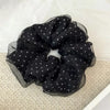 Black polka dot mesh scrunchie hair ties gathered in a circular shape