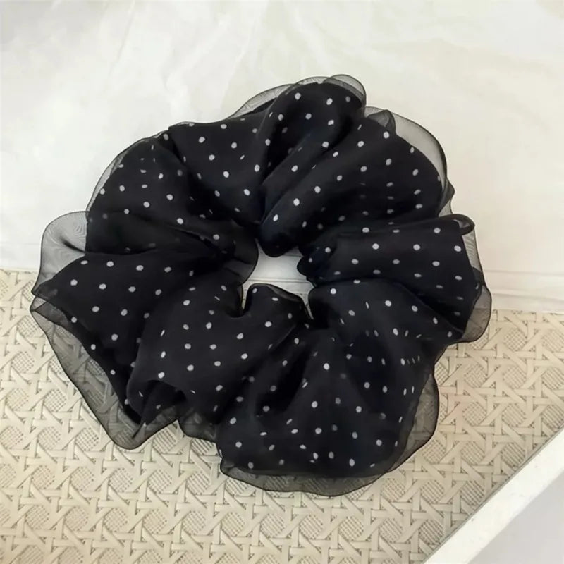 Black polka dot mesh scrunchie hair ties gathered in a circular shape