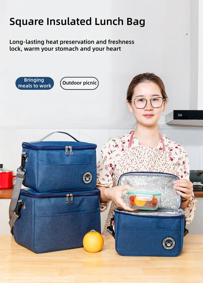 A woman holds a blue insulated lunch bag on a wooden table, demonstrating its features for food preservation.