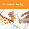 Hands wipe orange food splatters off a foldable aluminum stove guard surface.