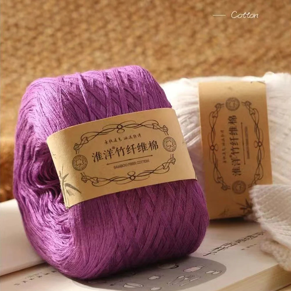 Purple pure cotton yarn skein for knitting and crochet displayed on a wooden surface.