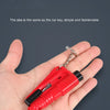 Una mano sostiene una pequeña herramienta de escape de coche de emergencia roja con una cadena de metal adjunta.