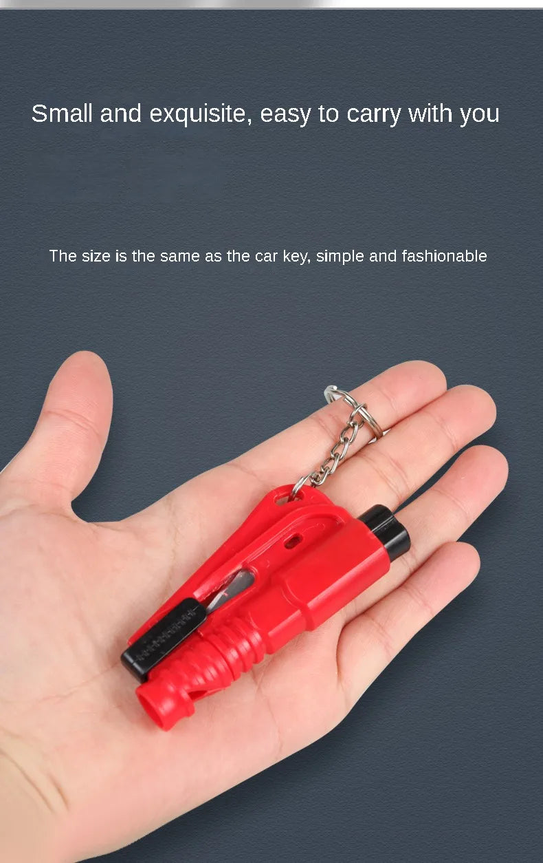 Una mano sostiene una pequeña herramienta de escape de coche de emergencia roja con una cadena de metal adjunta.