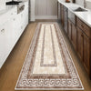 A long runner rug with geometric patterns in shades of brown, beige, and gray placed on a wooden floor between kitchen cabine