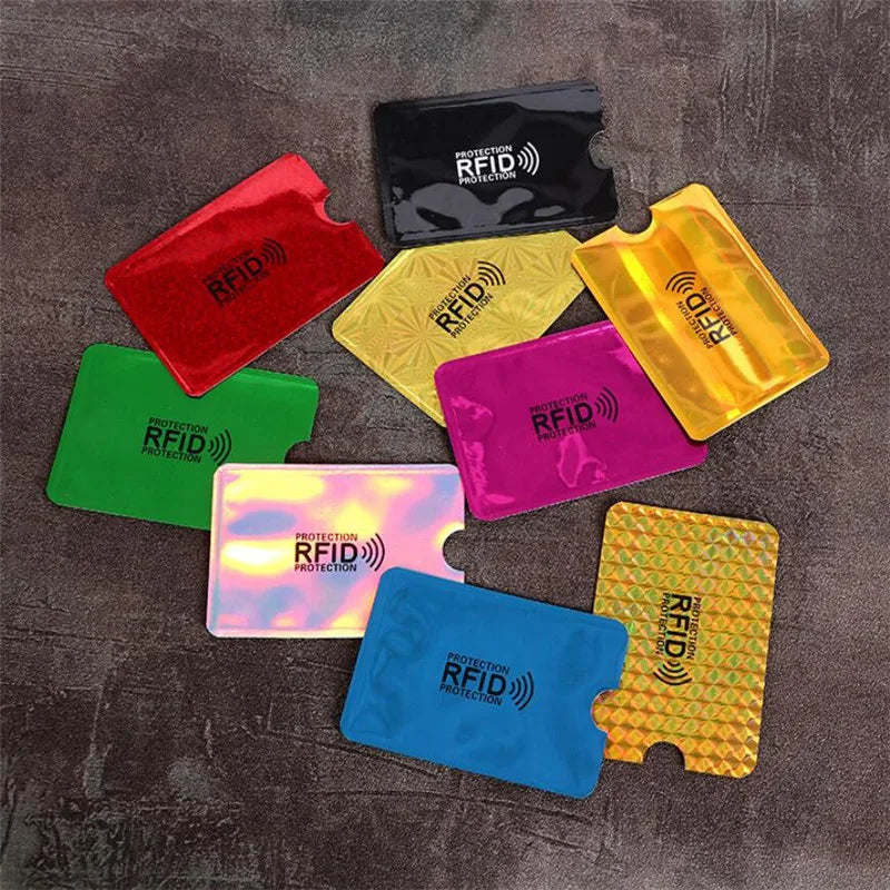 A collection of five colorful RFID protection aluminum card holders are displayed on a dark surface.