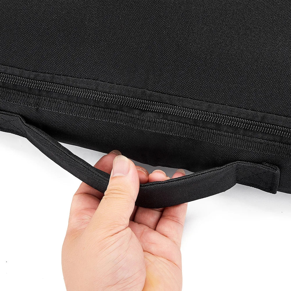 A hand is pulling open a black waterproof paddle board deck bag with a zipper and strap.