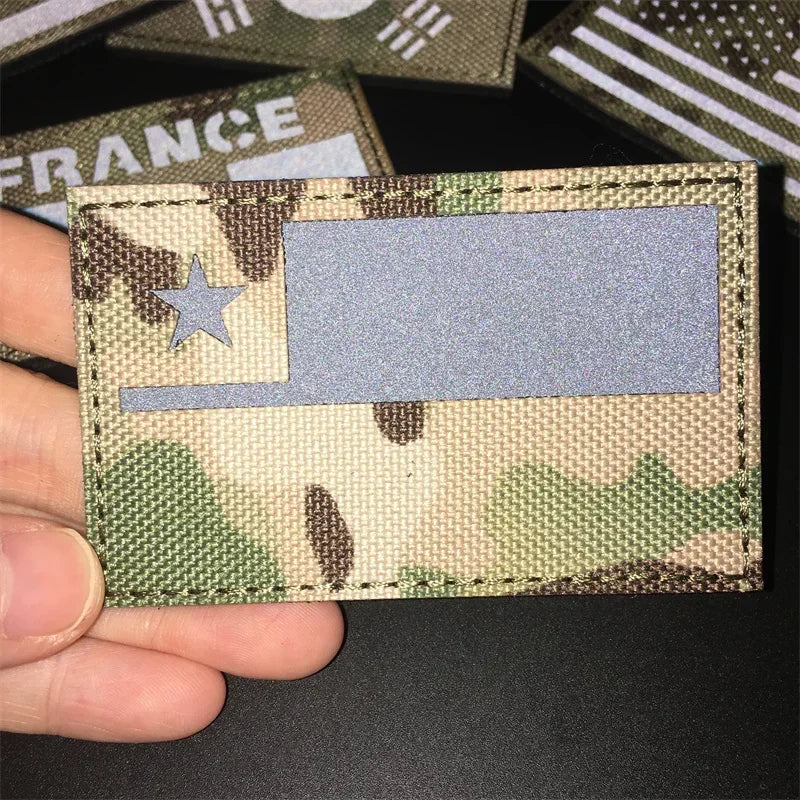 A tactical patch featuring the flag of France on a camouflage background with a star detail.