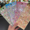 Eine Sammlung von rosa, blau und pfirsichfarbenen Mini-Sticker mit Tieren und Kuchen zum Journaling.