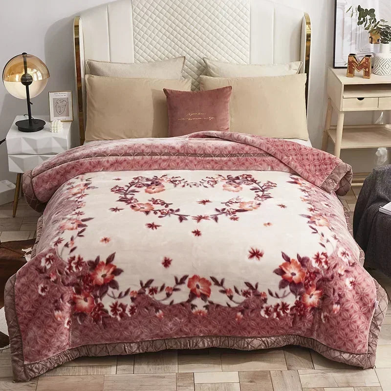 A beige weighted plush blanket with a pink floral pattern is displayed on a bed with white linens.