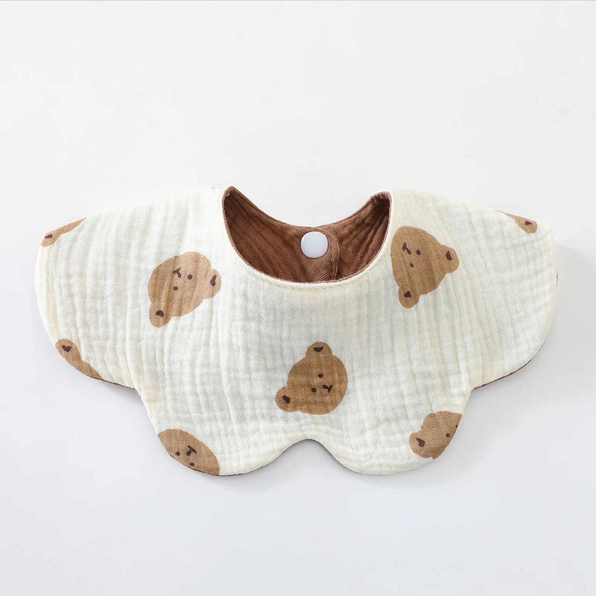 A cream-colored baby feeding bib with a brown bear design and a wooden-look collar.