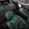 A close-up view of a black car seat cover with green accents and stitching inside a vehicle.
