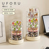 A clear rotating display case filled with various small collectible figurines and keepsakes.