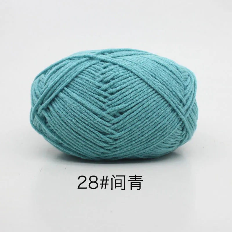 A ball of teal colored 4-ply milk cotton yarn for knitting and crochet.