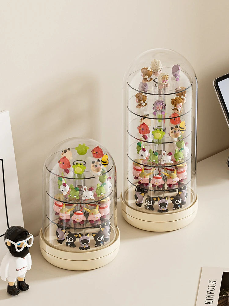 A clear, rotating display case holds various small collectible figures and keepsakes.