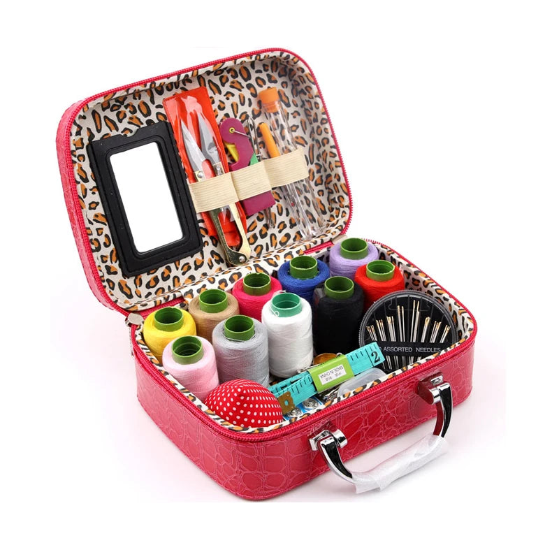 A red leather sewing kit box containing various needles, thread, and tools.