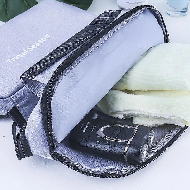 A purple hanging toiletry bag with a black zipper is open, revealing a white towel and a black bottle.