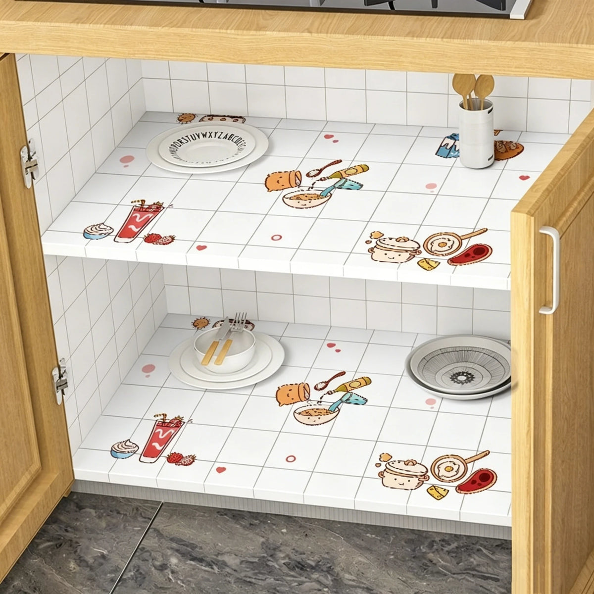 A kitchen cabinet interior showing white tiled shelves decorated with food and cooking utensils on a marble contact paper sur
