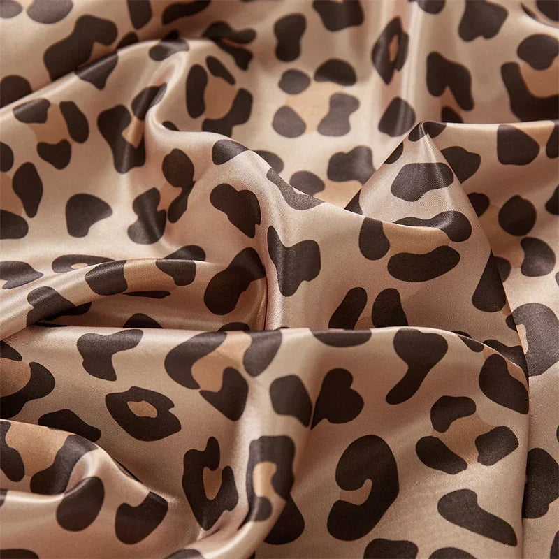 Flowing satin fabric with a brown and beige leopard print pattern