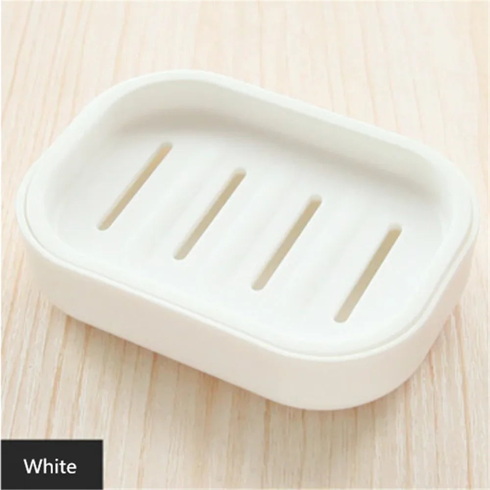 A white compact travel soap holder with a secure lid is shown on a light wooden surface.