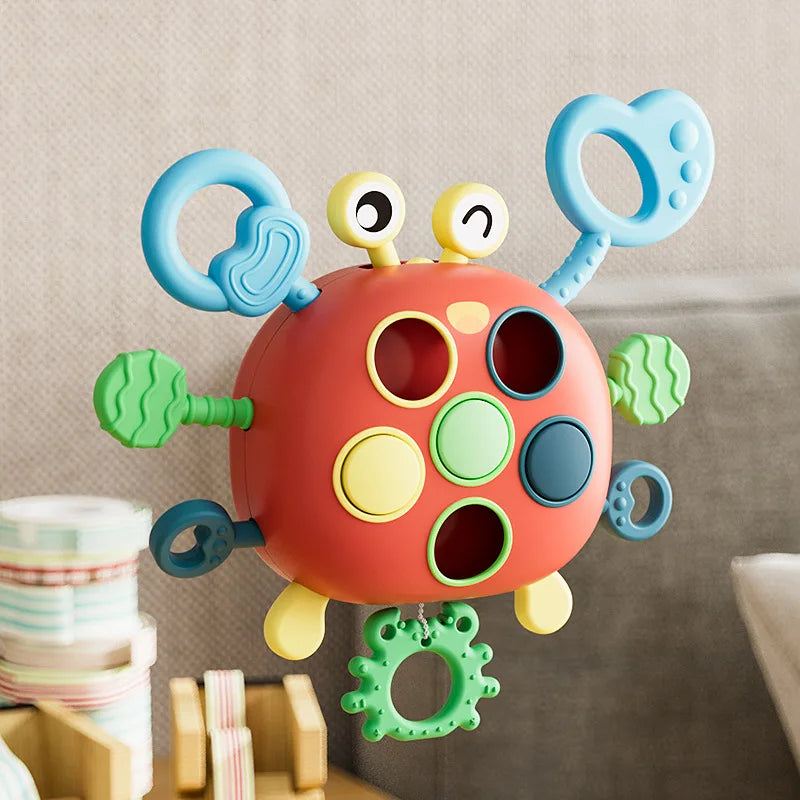 A colorful silicone pull string sensory toy with multiple rings and pull strings for babies.