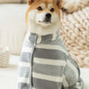 A Shiba Inu dog wearing a striped gray and white quick-dry ultra-absorbent bathrobe.