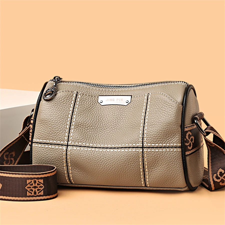 A beige vintage genuine leather women's shoulder bag with stitching and a leather strap.