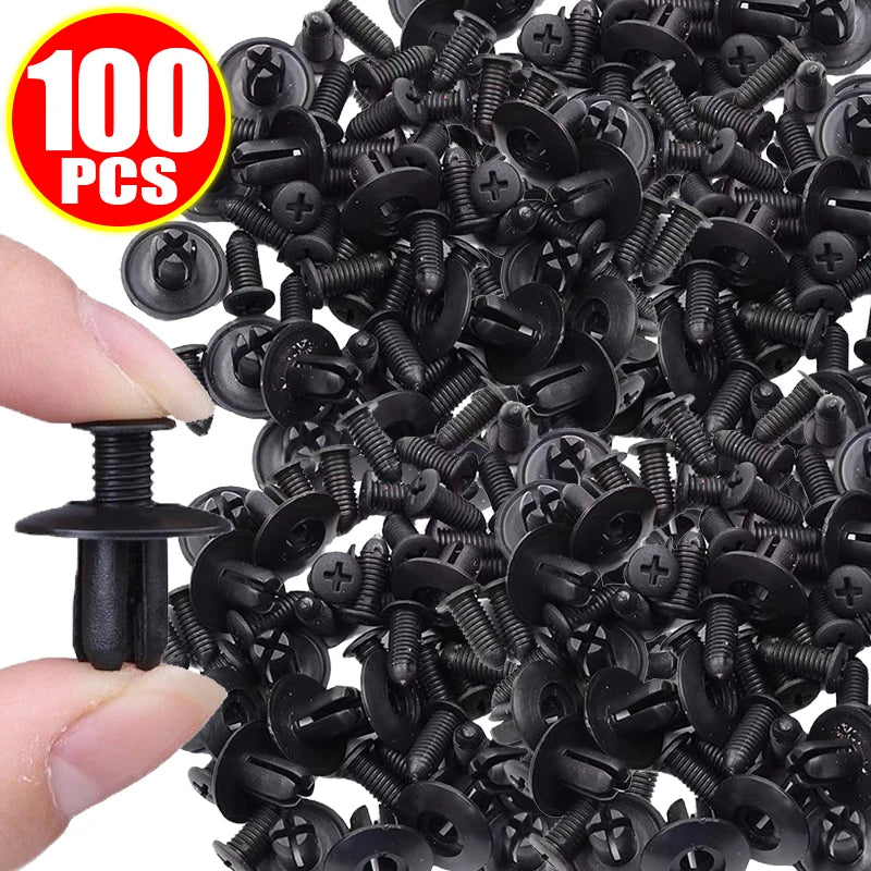 A close-up view of a pile of black heavy-duty plastic fasteners for automotive and DIY projects, with a hand holding one fast