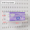 A tissue basket is placed on a shelf within a white desktop pegboard organizer.