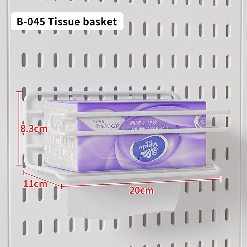 A tissue basket is placed on a shelf within a white desktop pegboard organizer.