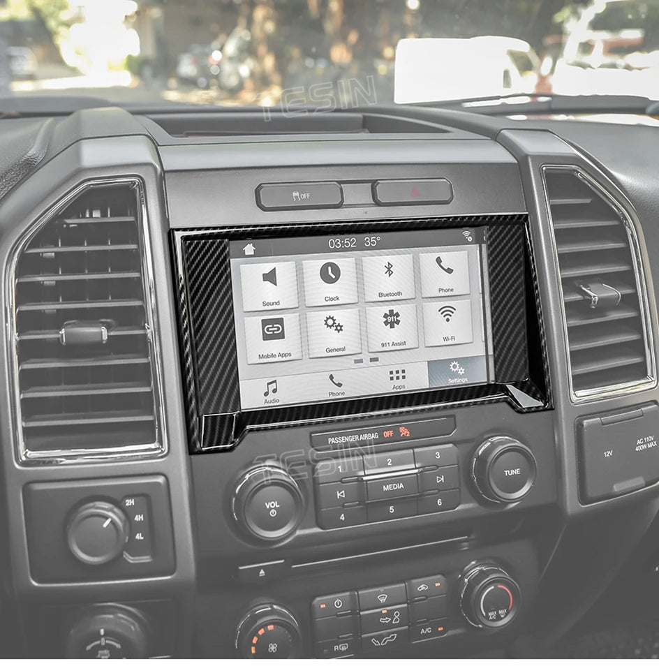 Interior view of a truck dashboard showing a carbon fiber grain center console trim cover and infotainment screen.