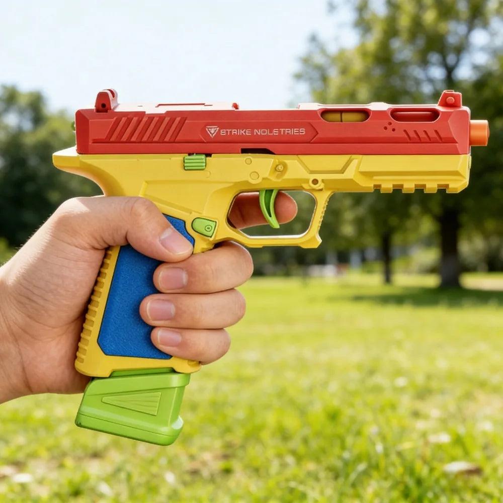 A hand holds a red and yellow building block toy pistol with shell ejecting action in an outdoor setting.